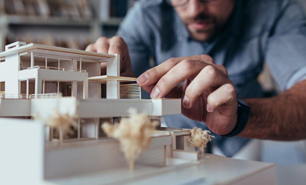 hotelnext: Mann baut ein Mini-Haus aus Pappe zusammen